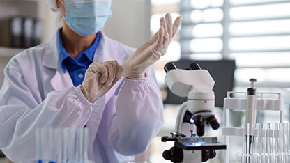Asian adult scientist preparing laboratory work putting on sterile gloves medical research experiment safety focus
